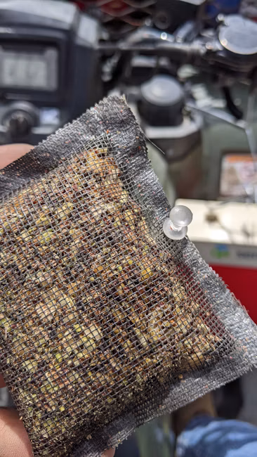 Mesh pouch containing ground pistachio mummies