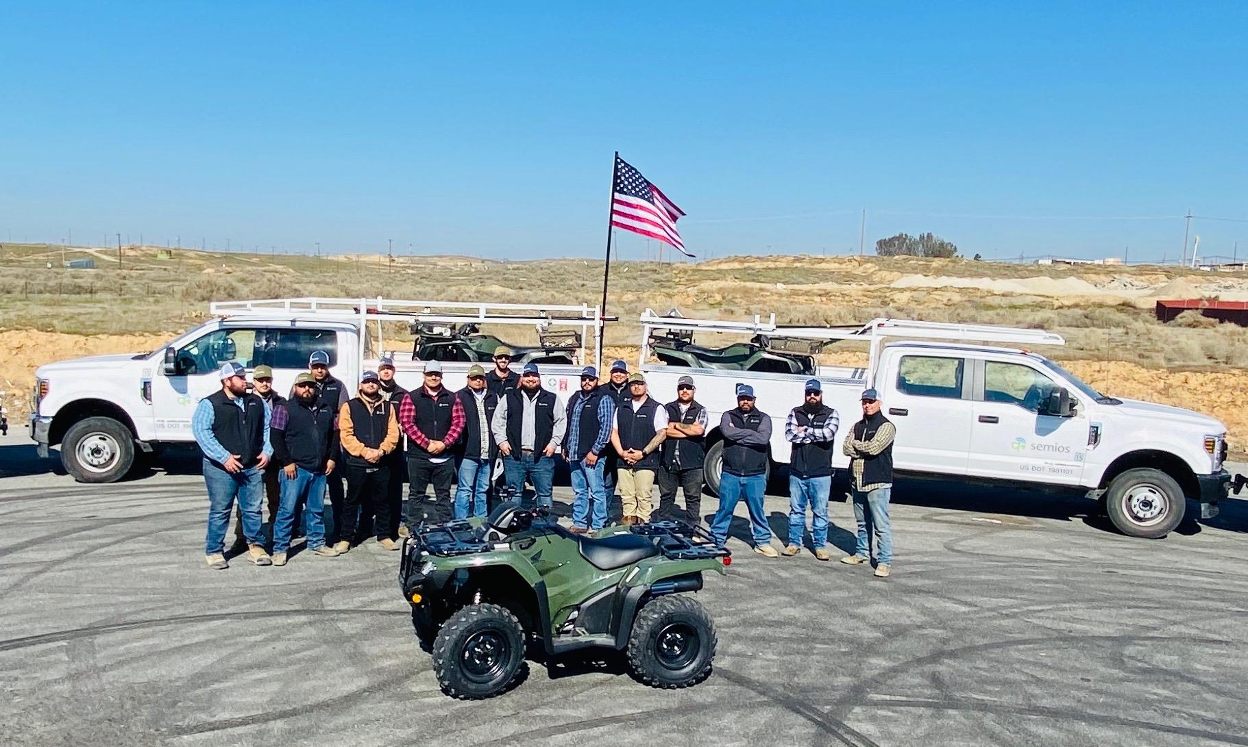 Semios field services team standing in front of service trucks and quads