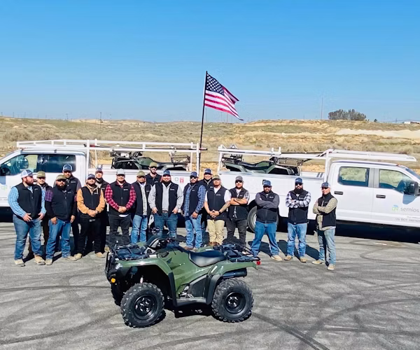 Semios field services team standing in front of service trucks and quads