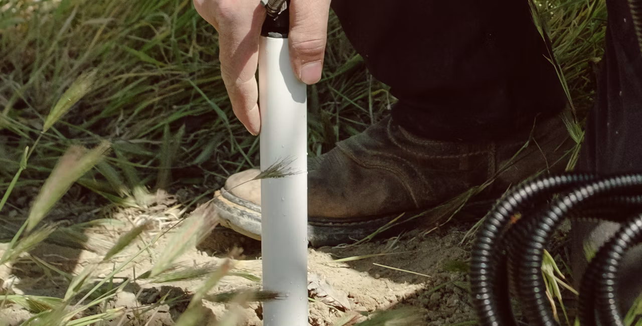 A hand installing a soil moisture probe