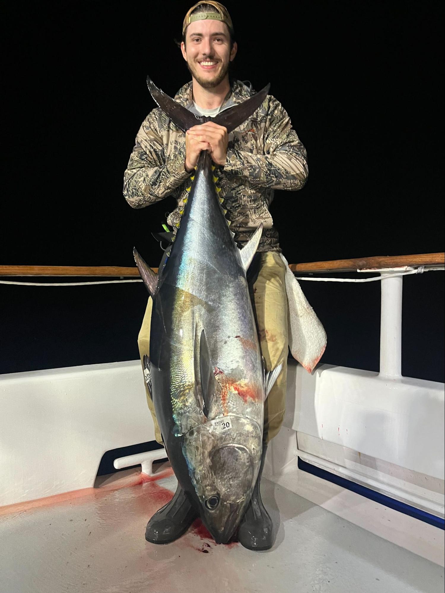 Dominic holding a large bluefin tuna on a boat
